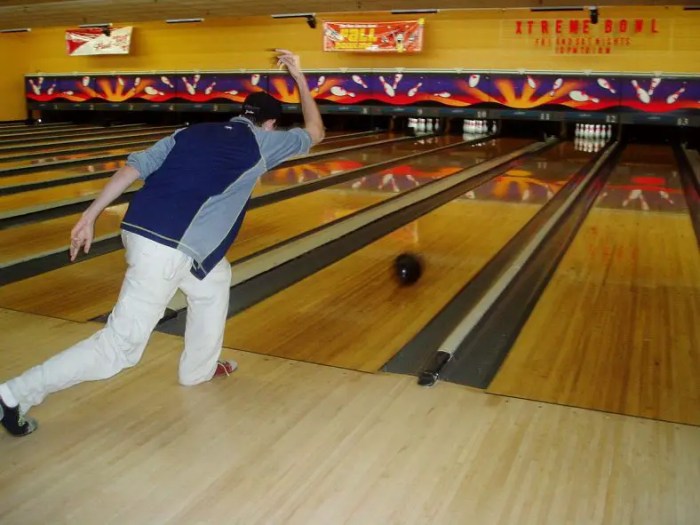 A bowler holds a bowling ball with mass